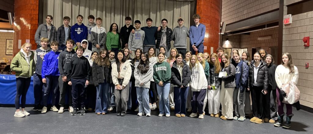 A group photo of 40 teens and one adult female taken in a gymnasium.