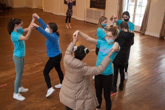 Teens of various racial backgrounds and ages dance together in a ballet class.