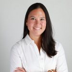 Image of a woman with brown hair wearing a white button-down blouse.