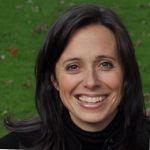 Image of White woman with brown hair wearing a black blouse.