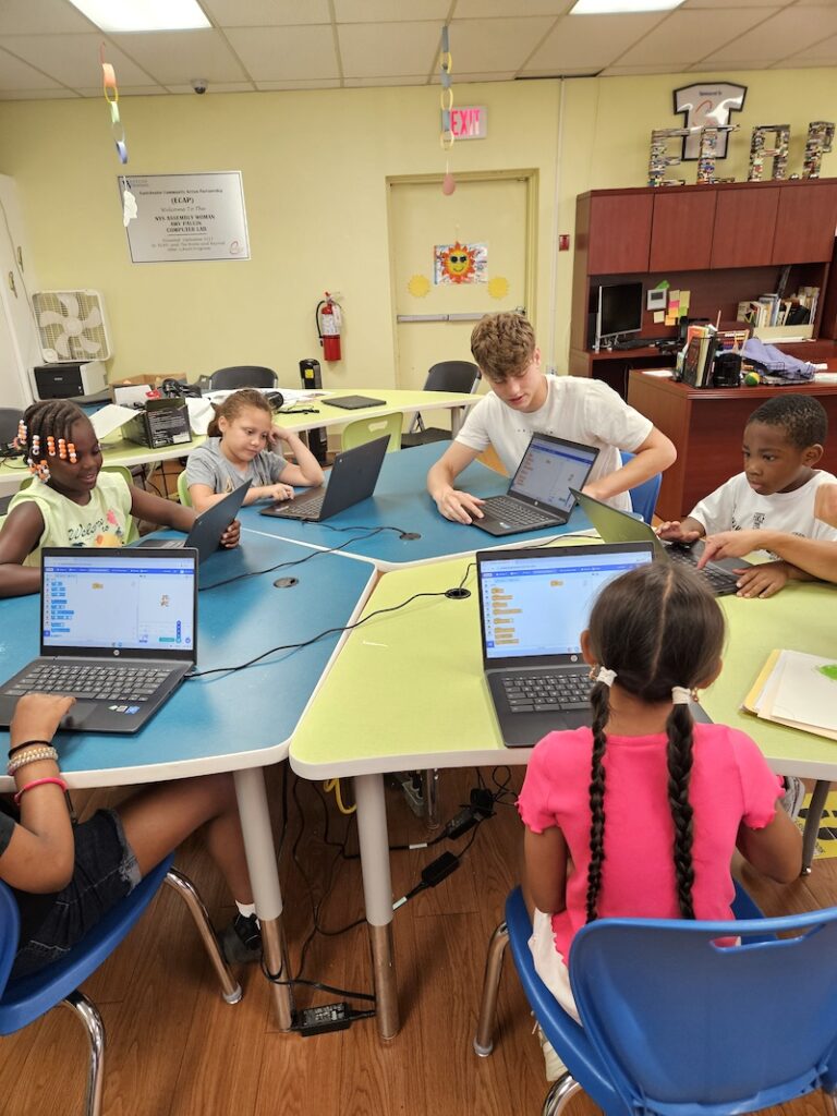 Elementary school participants work with a Youth Community Fund volunteer during an afterschool program.