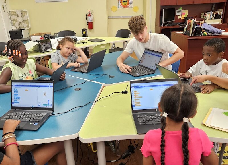 Elementary school participants work with a Youth Community Fund volunteer during an afterschool program.