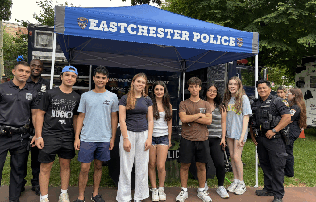 A group shot of student volunteers and police officers at a community event.
