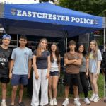 A group shot of student volunteers and police officers at a community event.