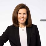 morrisroe-2026 Photo of a White woman with auburn hair wearing a business suit.